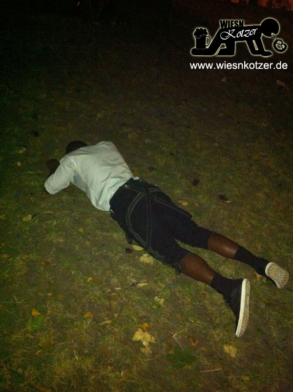 This guy lays on the ground with his face down in the grass.