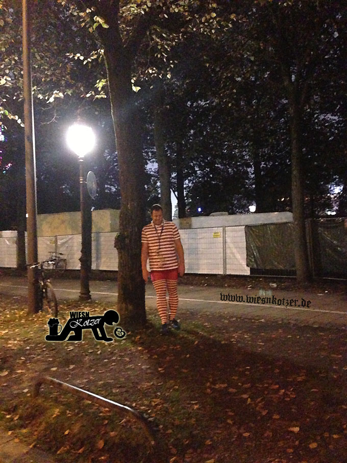drunken guy leaning at a tree in front of the oktoberfest